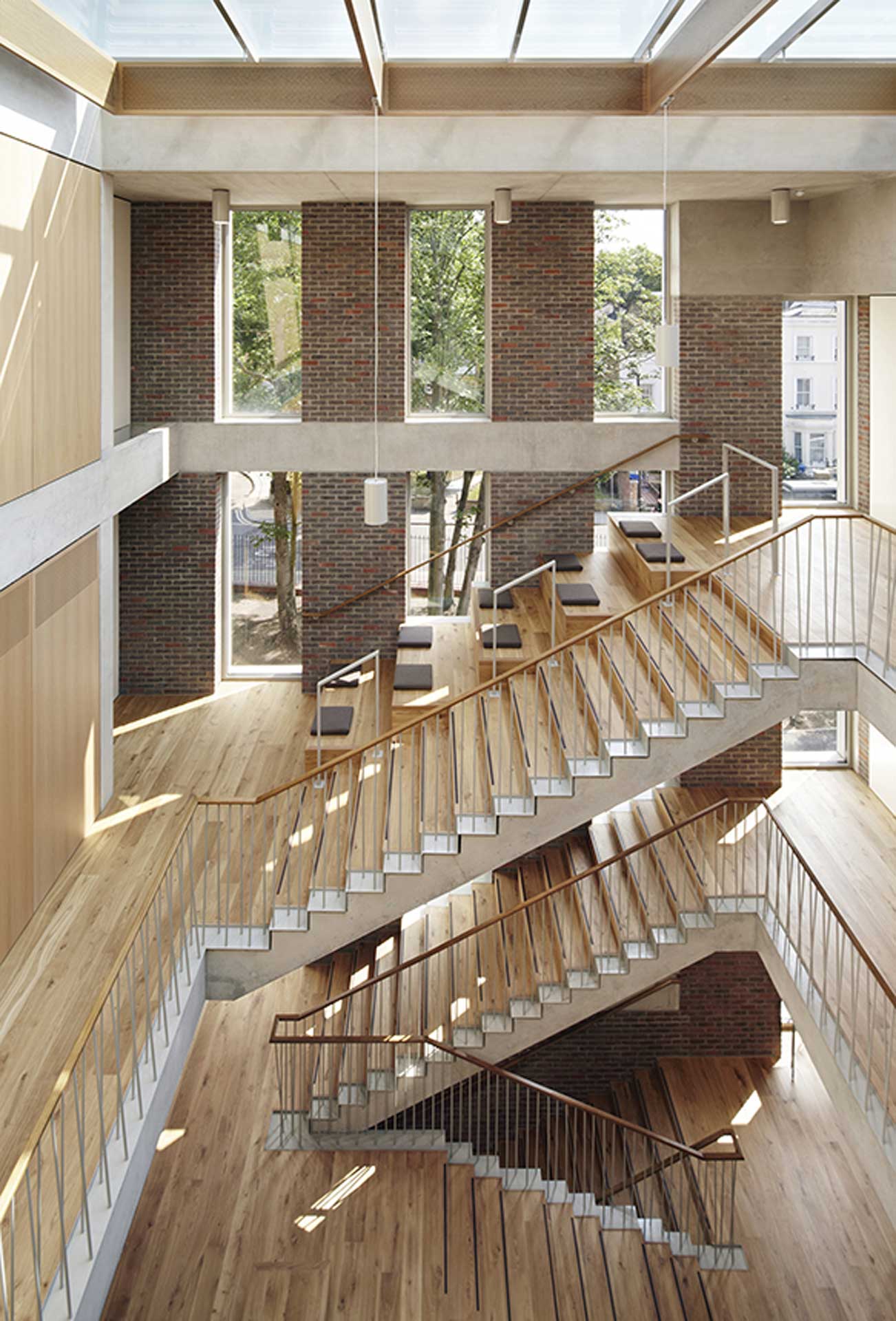 Interior view of a staircase with large windows with trees growing behind them