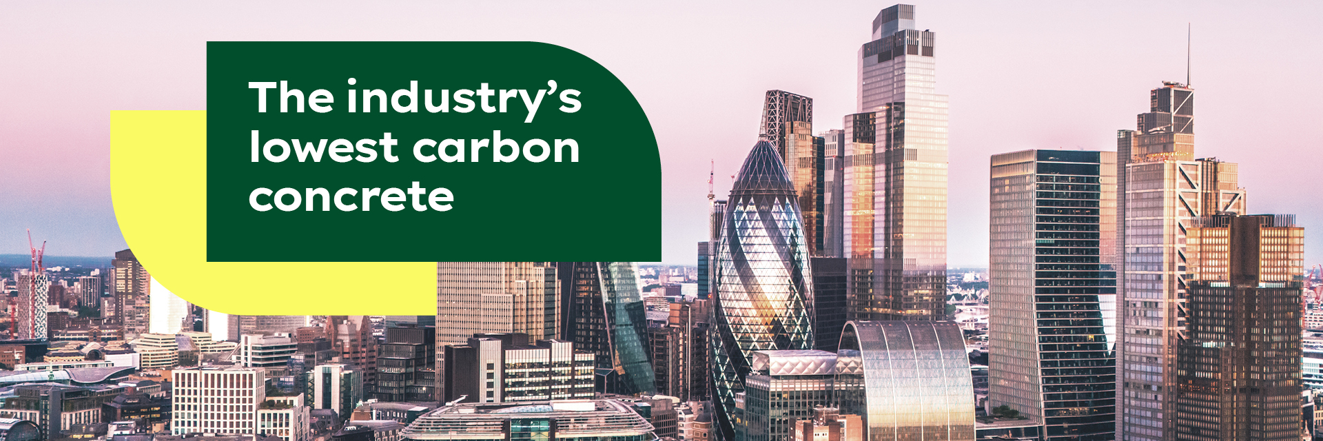 City skyline at sunset featuring modern skyscrapers, including the Gherkin, with a bold green and yellow banner on the left reading, "The industry’s lowest carbon concrete."